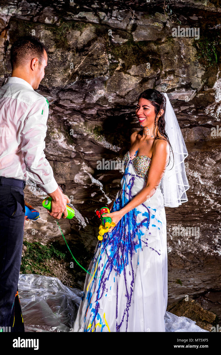 A Trash the Dress shoot in the Italian mountains by a small waterfall. First the couple went under the waterfall and then threw paint at each other. Stock Photo
