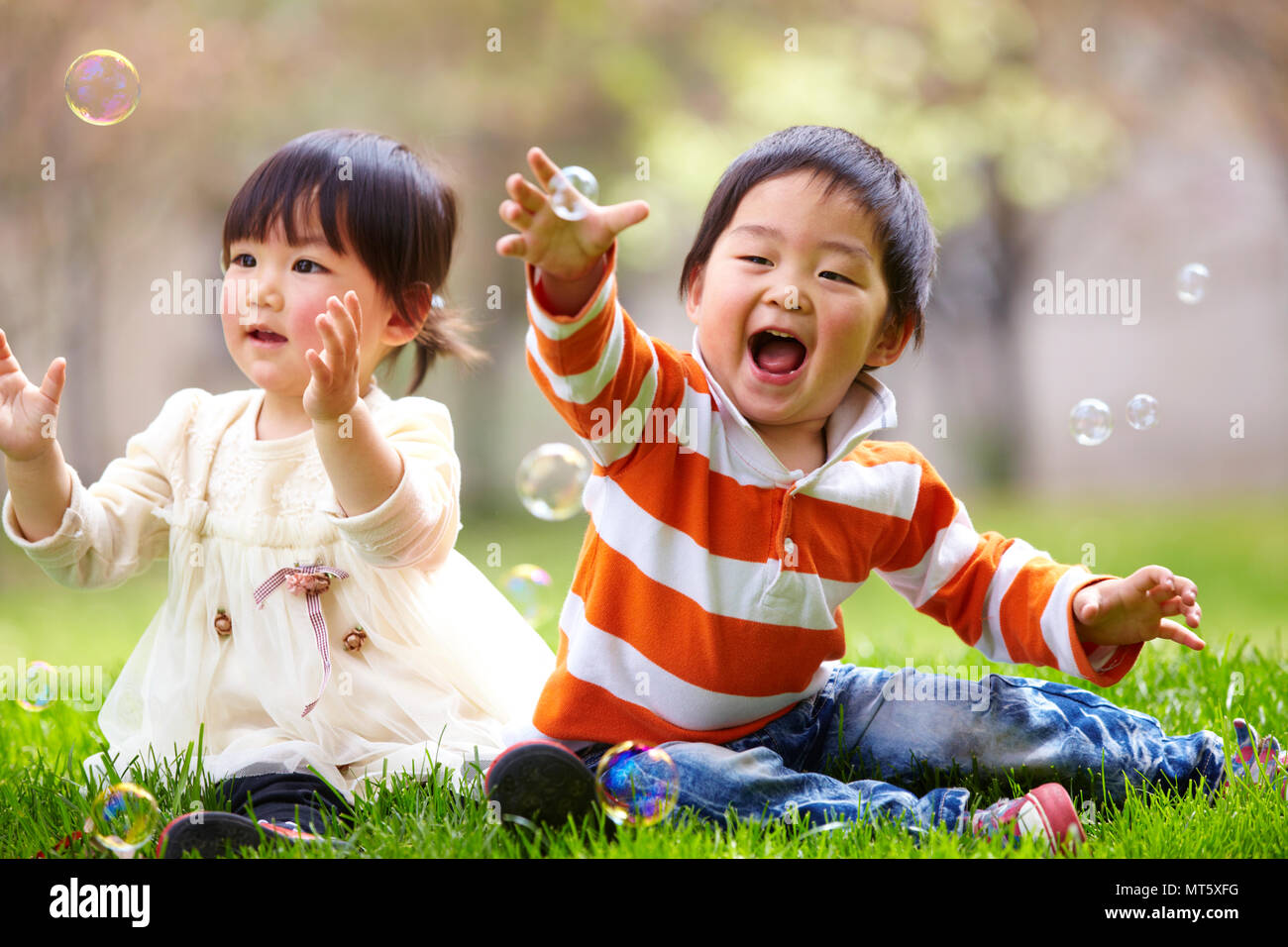 Two happy little asian kids playing outdoor in the sunny park Stock Photo -  Alamy