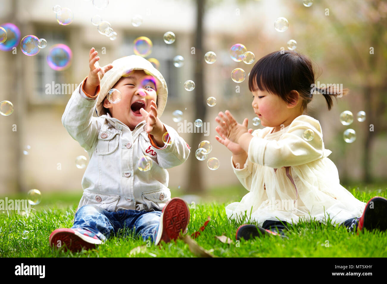 Two happy little asian kids playing outdoor in the sunny park Stock Photo -  Alamy