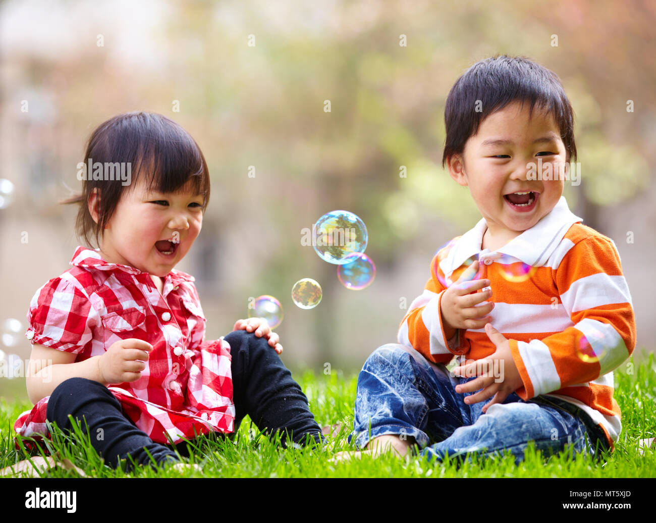 Two happy little asian kids playing outdoor in the sunny park Stock Photo -  Alamy
