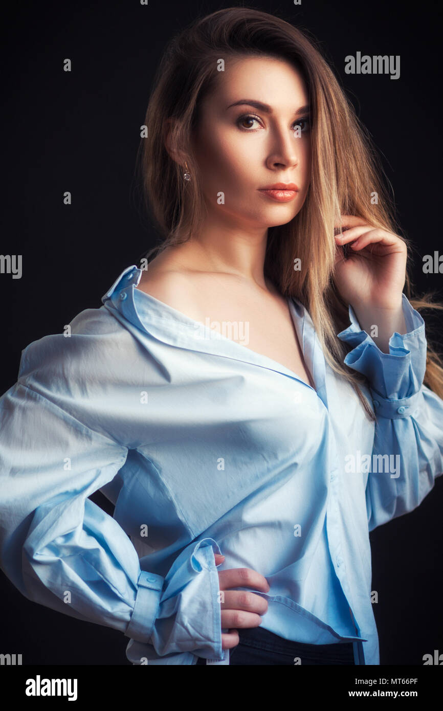 Portrait of young pretty woman posing and looking at camera over black ...