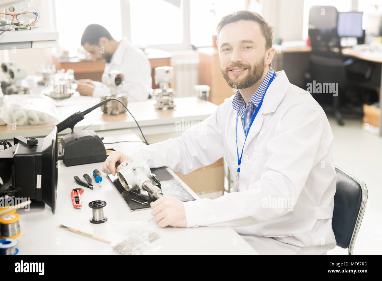 Qualified lab technician analyzing manometer in workshop Stock Photo