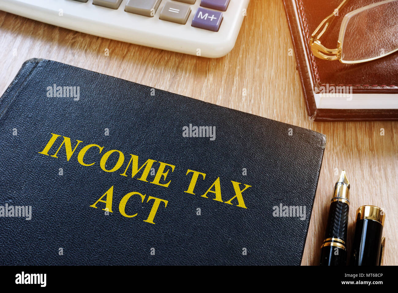 Income tax act and calculator on a desk. Stock Photo