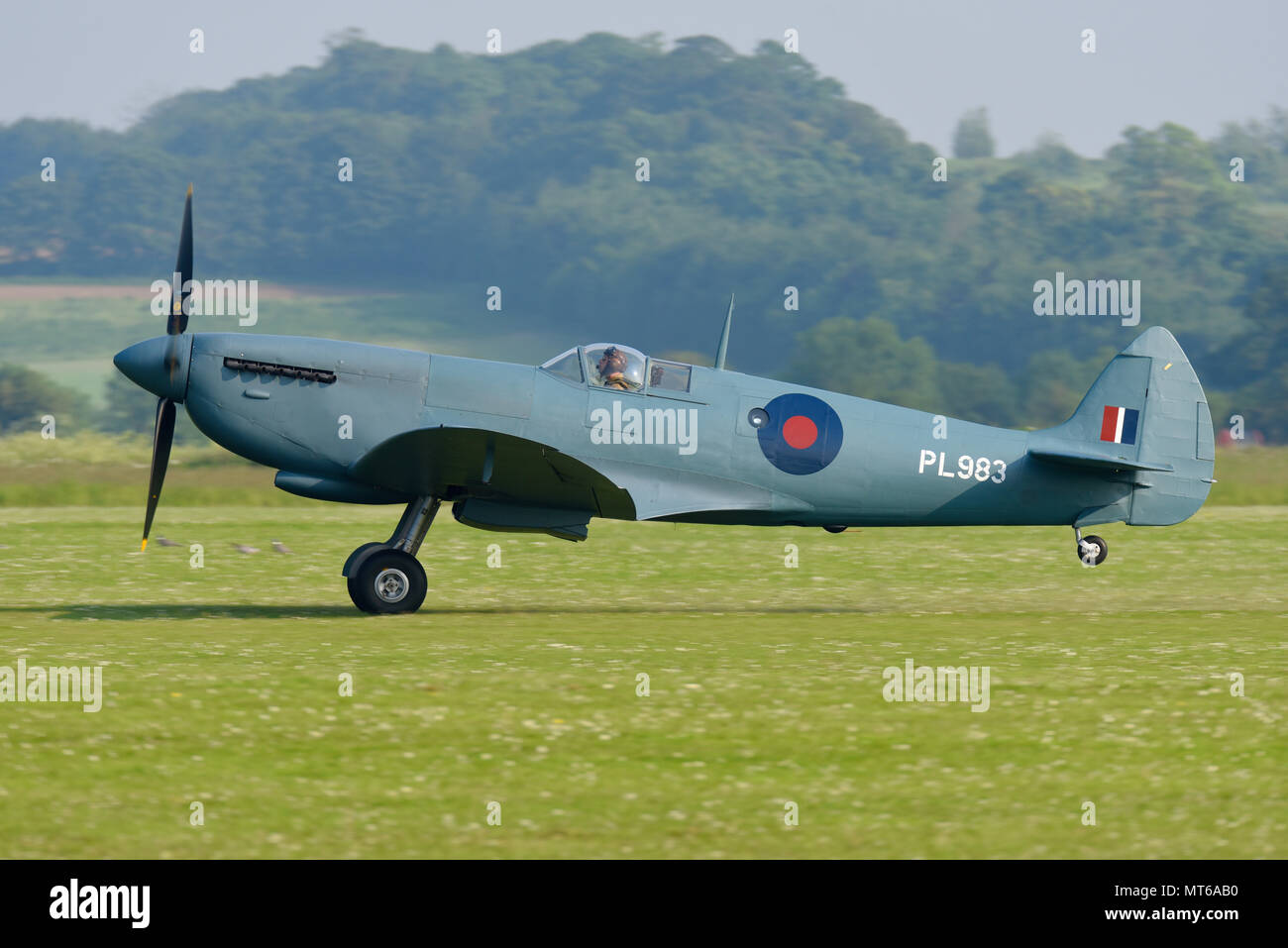 Supermarine Spitfire PRXI PL983 newly restored second world war plane taking off for a test flight from a grass runway Stock Photo