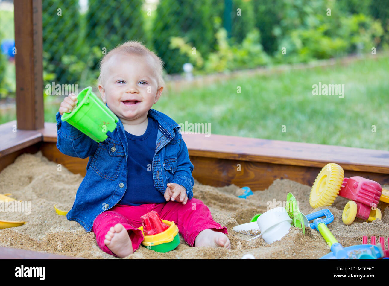 Little baby boy, playing in a sandpit with toys outdoors Stock Photo