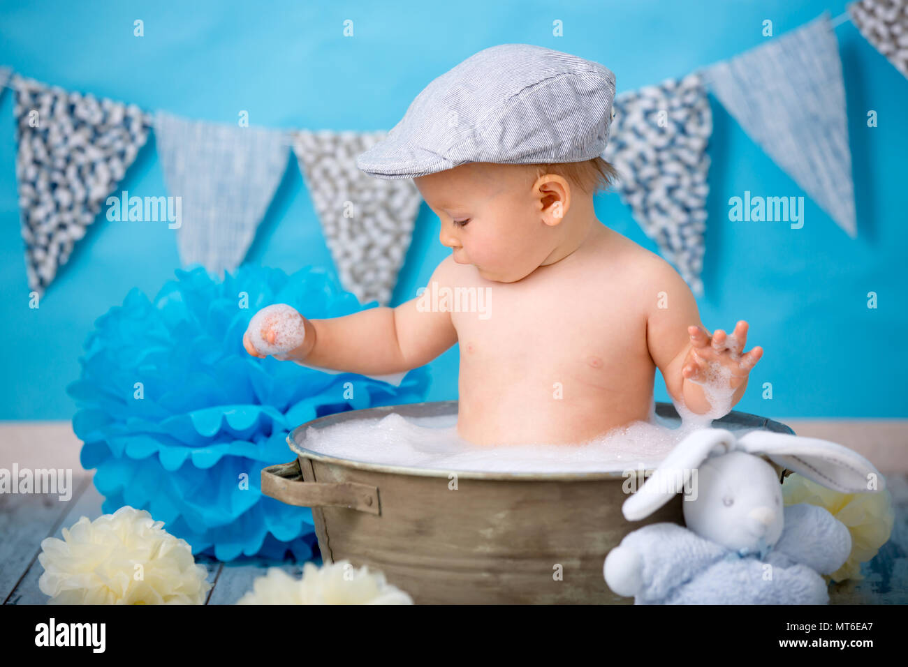 Cute baby boy, having bath after smash cake, isolated shot on blue