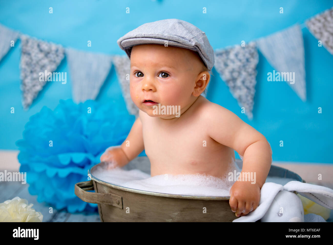 Cute baby boy, having bath after smash cake, isolated shot on blue