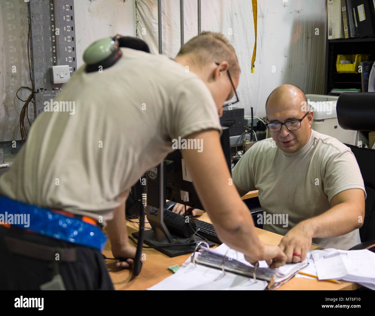 U.S Air Force Tech. Sgt. Juan Pacheco, right, a customer support liaison with the 763rd Expeditionary Aircraft Maintenance Unit, processes an order request for a part at Al Udeid Air Base, Qatar, July 27, 2017. Pacheco is responsible for managing the 763rd EAMU inventory and ensures financial accountability for all of the supplies. (U.S. Air Force photo by Tech. Sgt. Amy M. Lovgren) Stock Photo