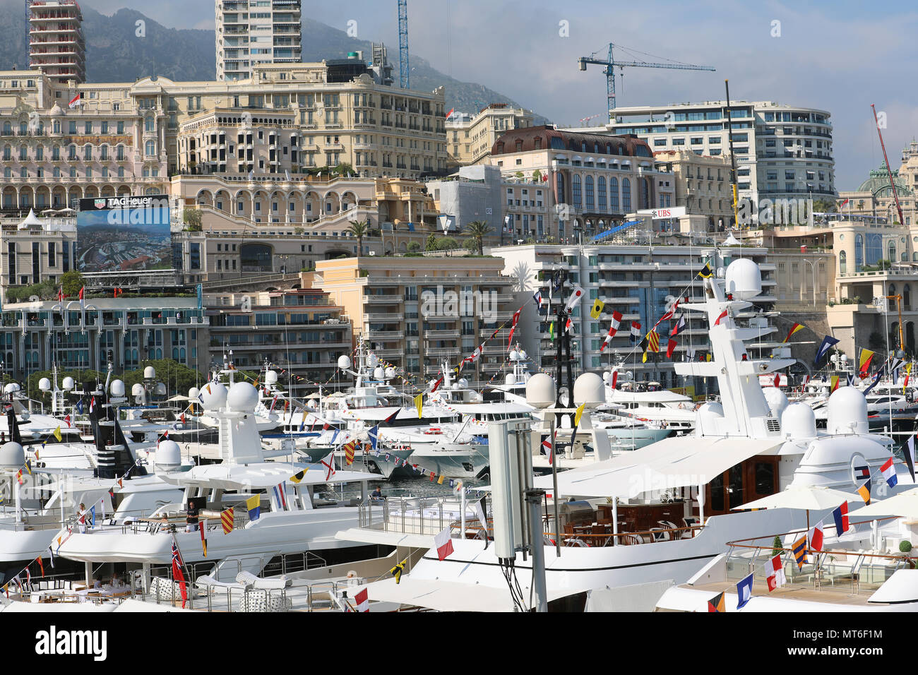 Monte-Carlo, Monaco - May 24, 2018: Many Luxurious Yachts Moored at Port Hercule, Architecture of Buildings And Skyscrapers in The Background.  Princi Stock Photo