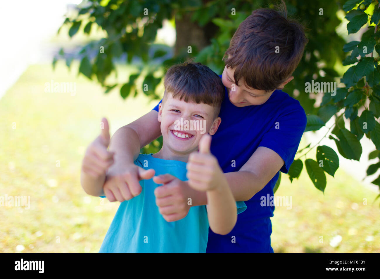 Happy young boys have fun together in park Stock Photo