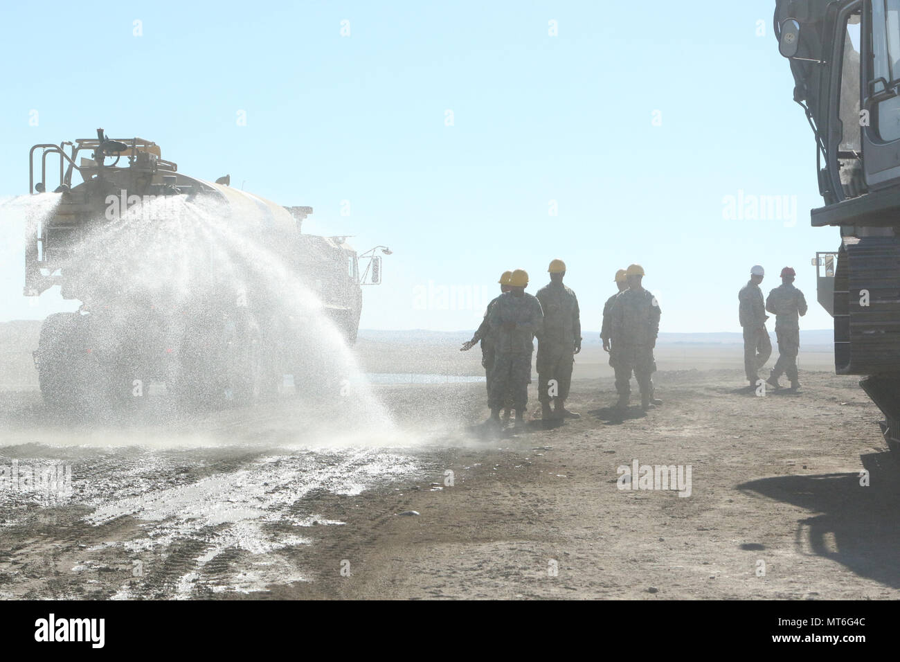 U.S. Army Reserve Soldiers assigned to the 317th Engineer Construction Company, spray water on the soil in order to help form it at the Blackfeet Indian Reservation near Browning, Mont., July 30, 2017. The 317th ECC which is assigned to the 863rd Engineer Brigade, 416th Theater Engineer Command, at Homewood, IL, spent two months in northwest Montana constructing roads for the local population for the purpose of mission essential training and helping to the local community. (U.S. Army Reserve photo by SPC Robert Torres) Stock Photo