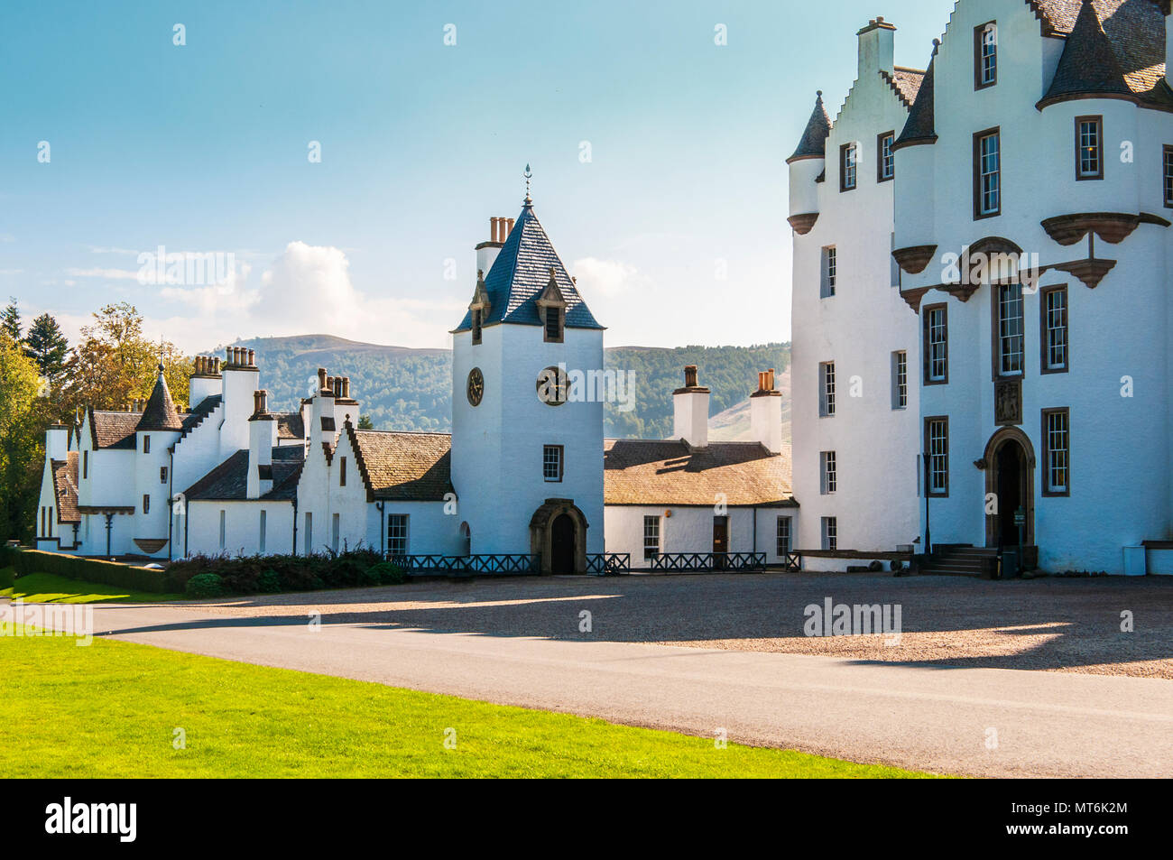 The magnificent white grade A listed building of Blair Castle, the ancestral home of the Clan Murray, with the newer clock tower and outbuildings Stock Photo