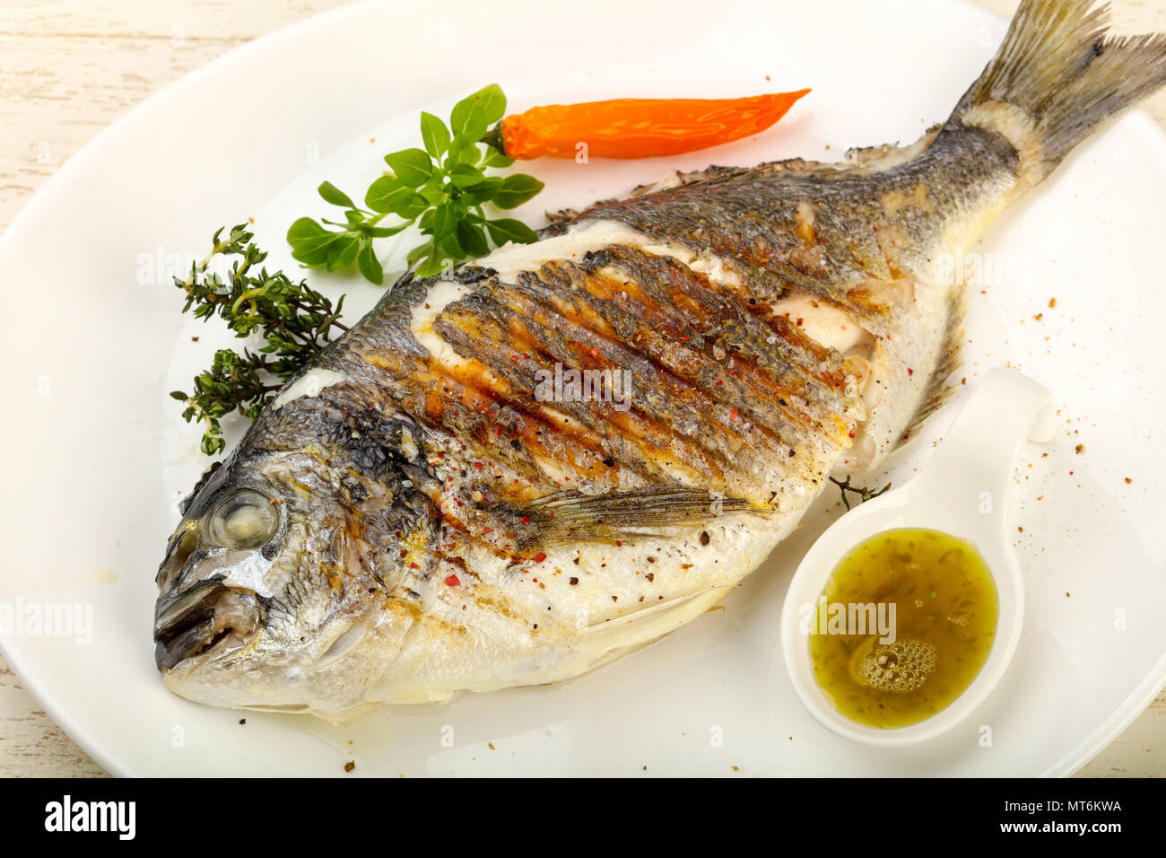 Grilled dorado fish with sauce, thyme and basil Stock Photo - Alamy