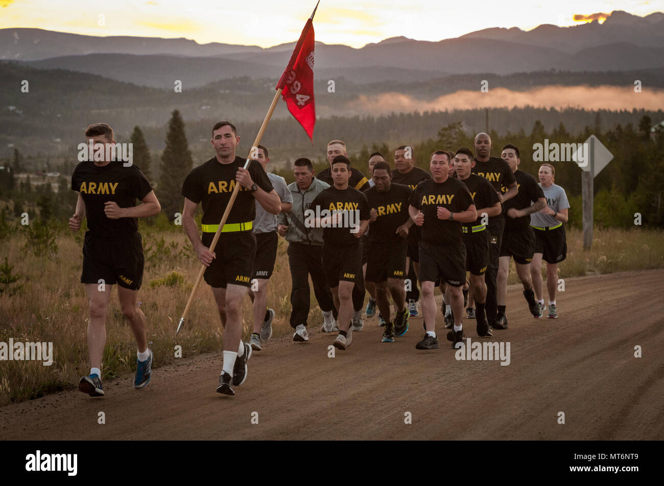 U.S. Army Reserve Spc. Gage Dean, the guidon carrier and a carpentry and masonry specialist with 994th Engineering Company out of Denver leads soldiers during a group run, meant to serve as a culmination of their two-week annual training at the YMCA of the Rockies - Snow Mountain Ranch, Granby, Colorado, July 21, 2017. (U.S. Army Reserve photo by Spc. Miguel Alvarez, 354th Mobile Public Affairs Detachment) Stock Photo