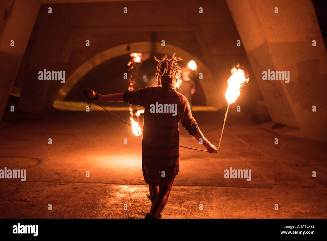Fire spinner in-action, below the bridge of M25 near London, UK. Stock Photo
