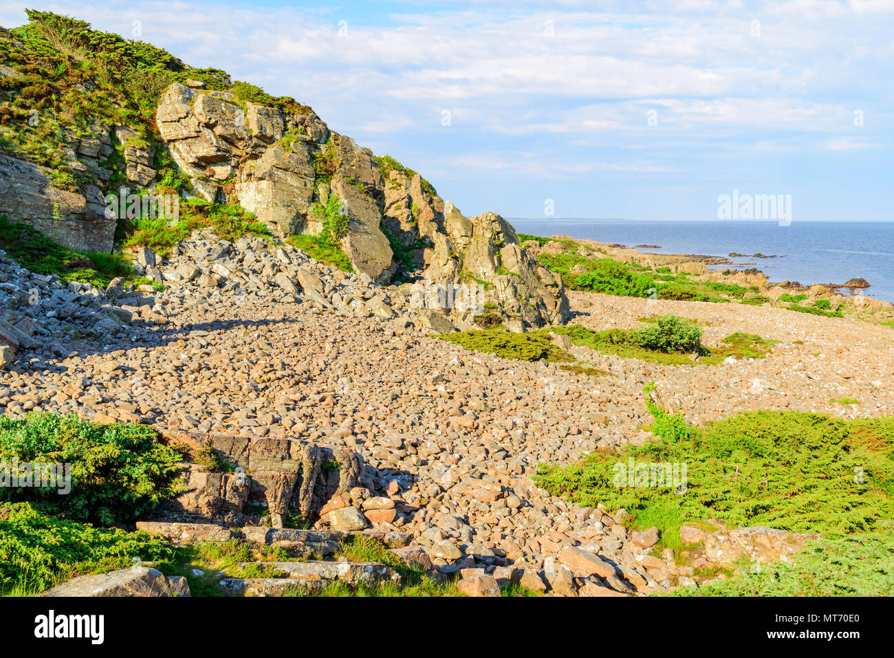 The rocky coastal landscape at Hovs hallar in the Bjare coast nature reserve in Sweden. It is a sunny and calm morning. Stock Photo