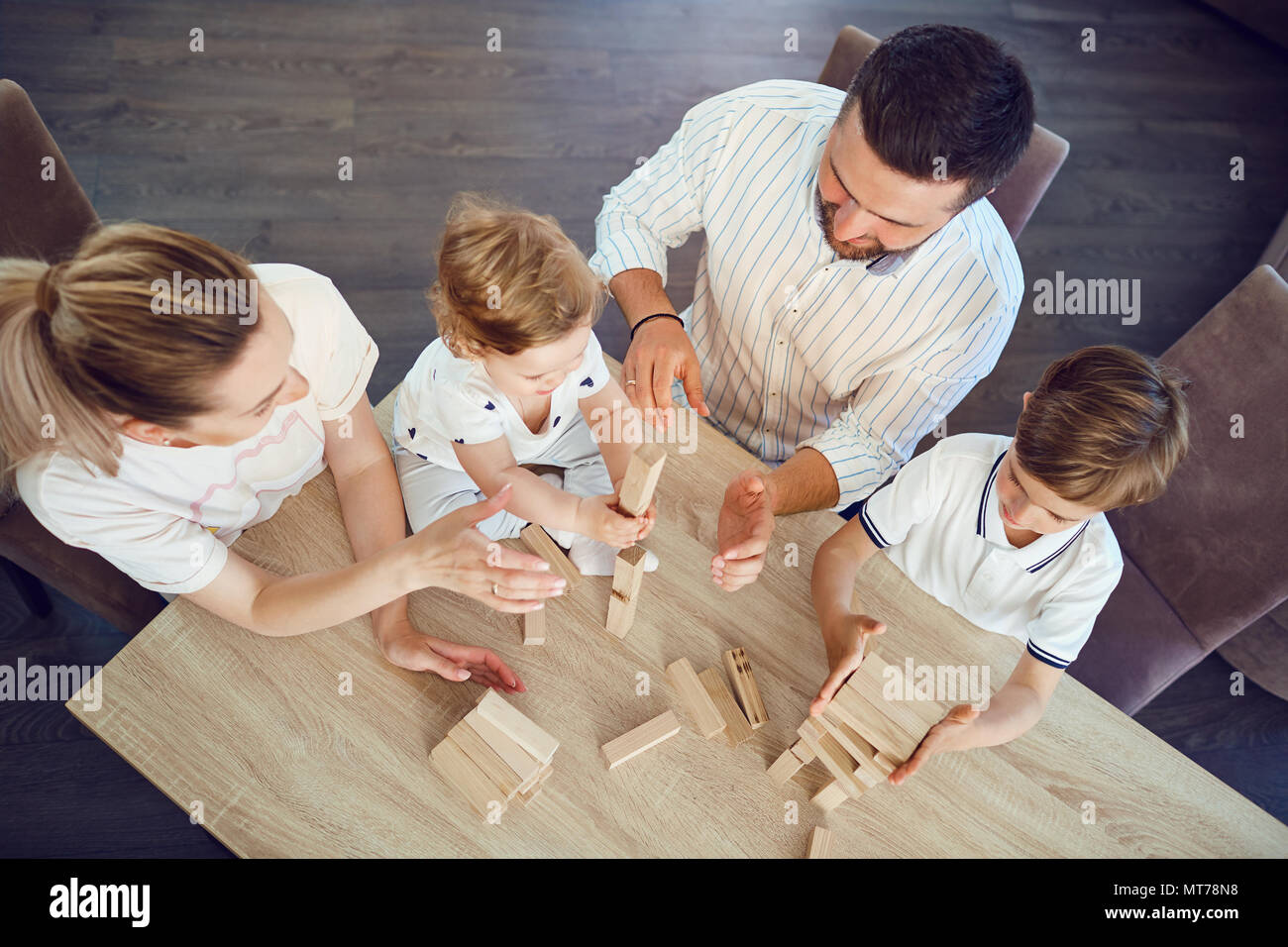 Top view of the family playing board games at a table. Stock Photo