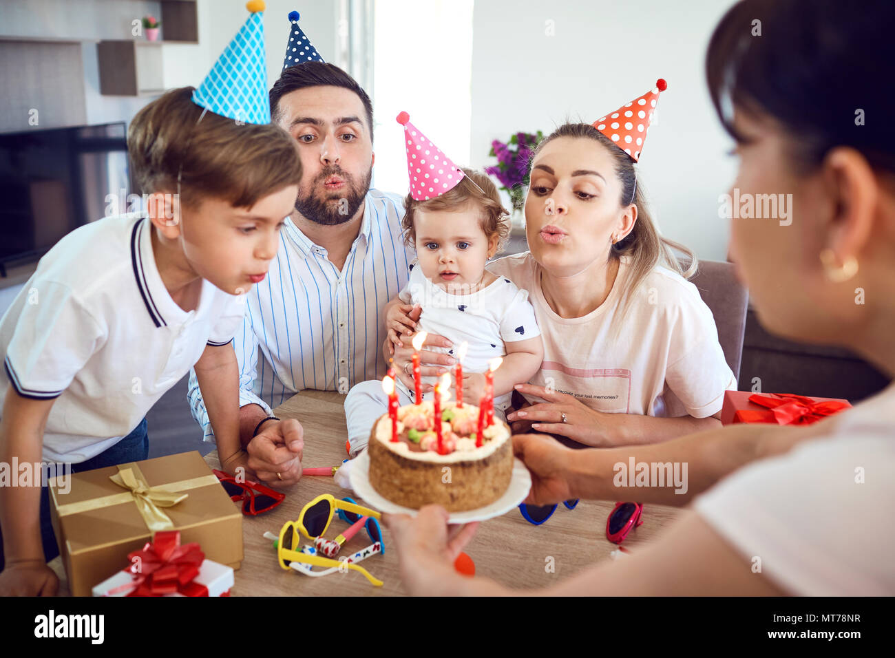 A happy family with a candle cake celebrates a birthday party Stock Photo