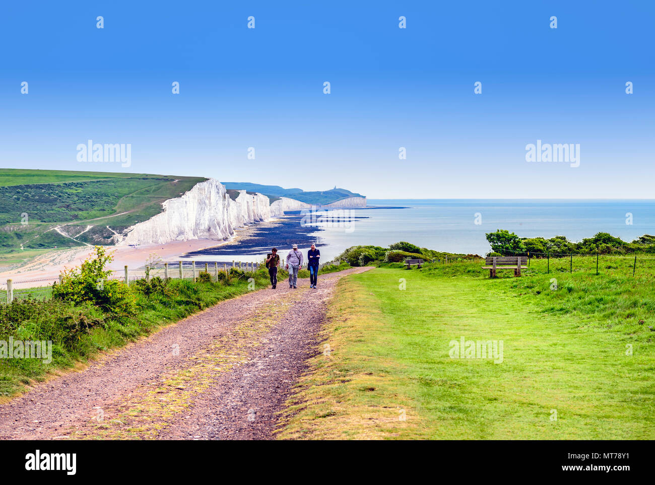 walkers at seaford head with a view of the seven sisters cliffs in the background Stock Photo