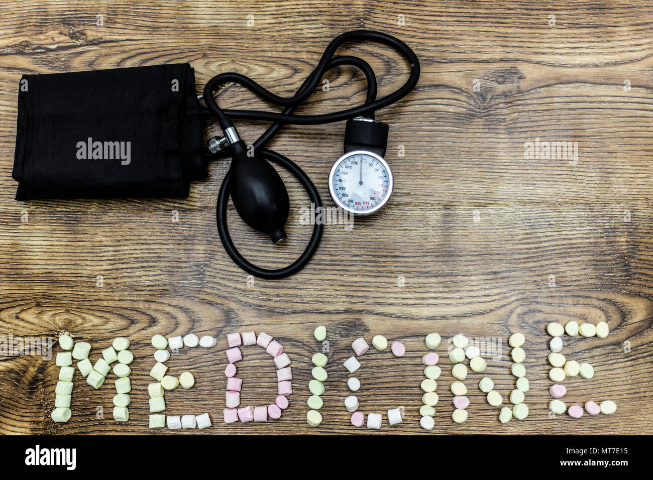 Scale of pressure and marshmallow balls forming the word MEDICINE