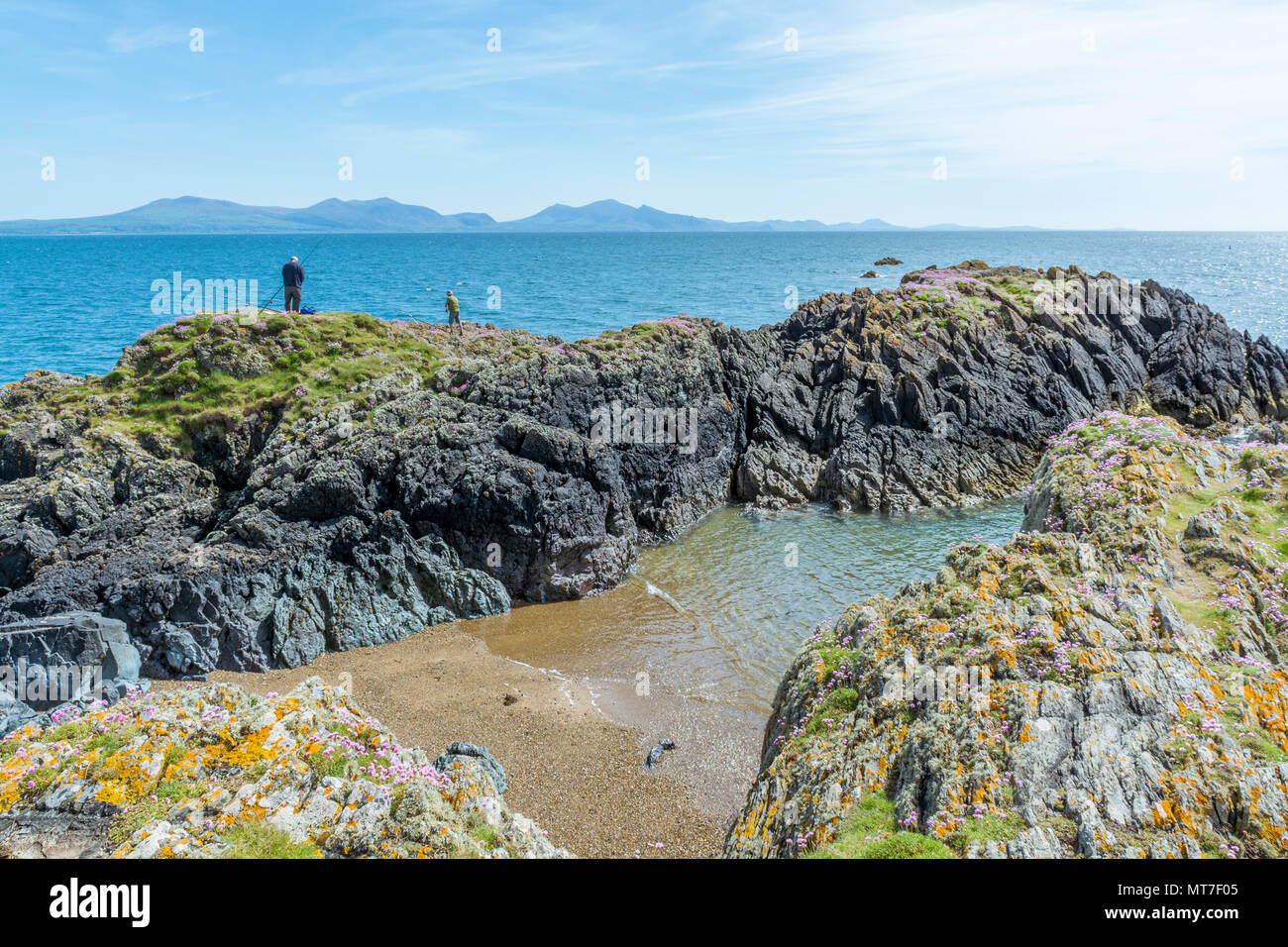 UK, Anglesey, Newborough. 19th May 2018. A couple of fishermen catch fish from the rocks at Llanddwyn Island. Stock Photo