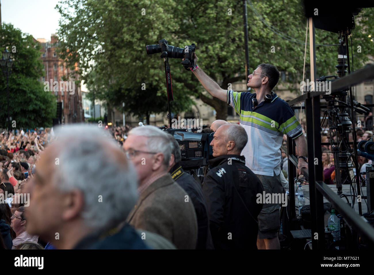 Photographer Joel Goodman photographs during the Manchester Together choir concert remembering the victims of the Arena bomb attack in Manchester, Britain, on May 22, 2018. Prince William and British Prime Minister Theresa May joined other politicians, as well as family members of those killed, and first responders to the scene of the terror attack, whilst thousands of people gathered in Manchester Tuesday on the first anniversary of a terror attack in the city which left 22 people dead. Stock Photo
