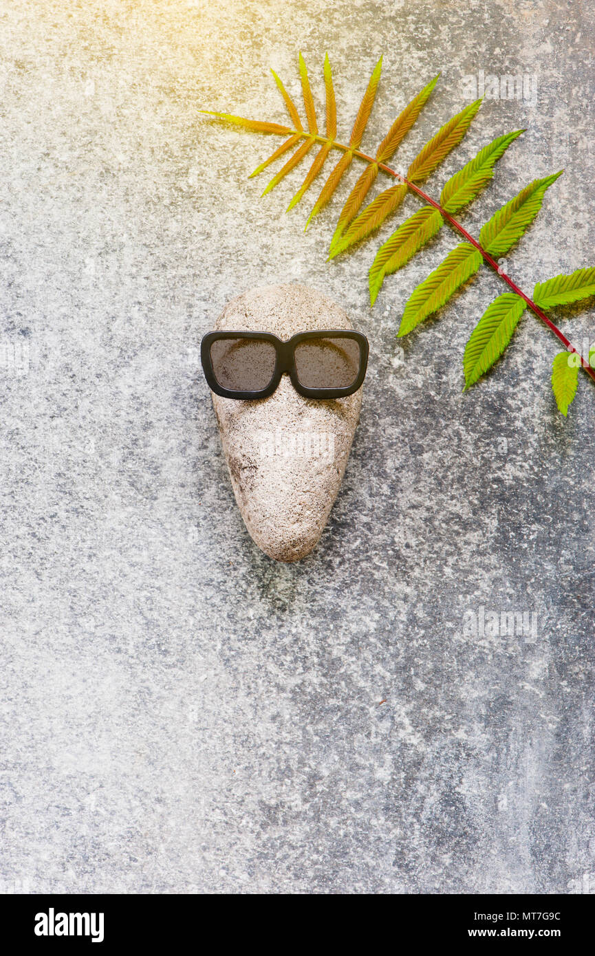 Background with funny character of stones on the grey textured surface, copy space Stock Photo