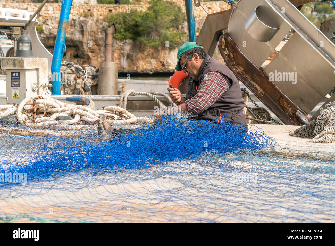 Fischer beim reparieren des Netz in  Cala Figuera, Mallorca, Balearen, Spanien  |  fisherman repairing his fishing net at Cala Figuera bay, Majorca, B Stock Photo