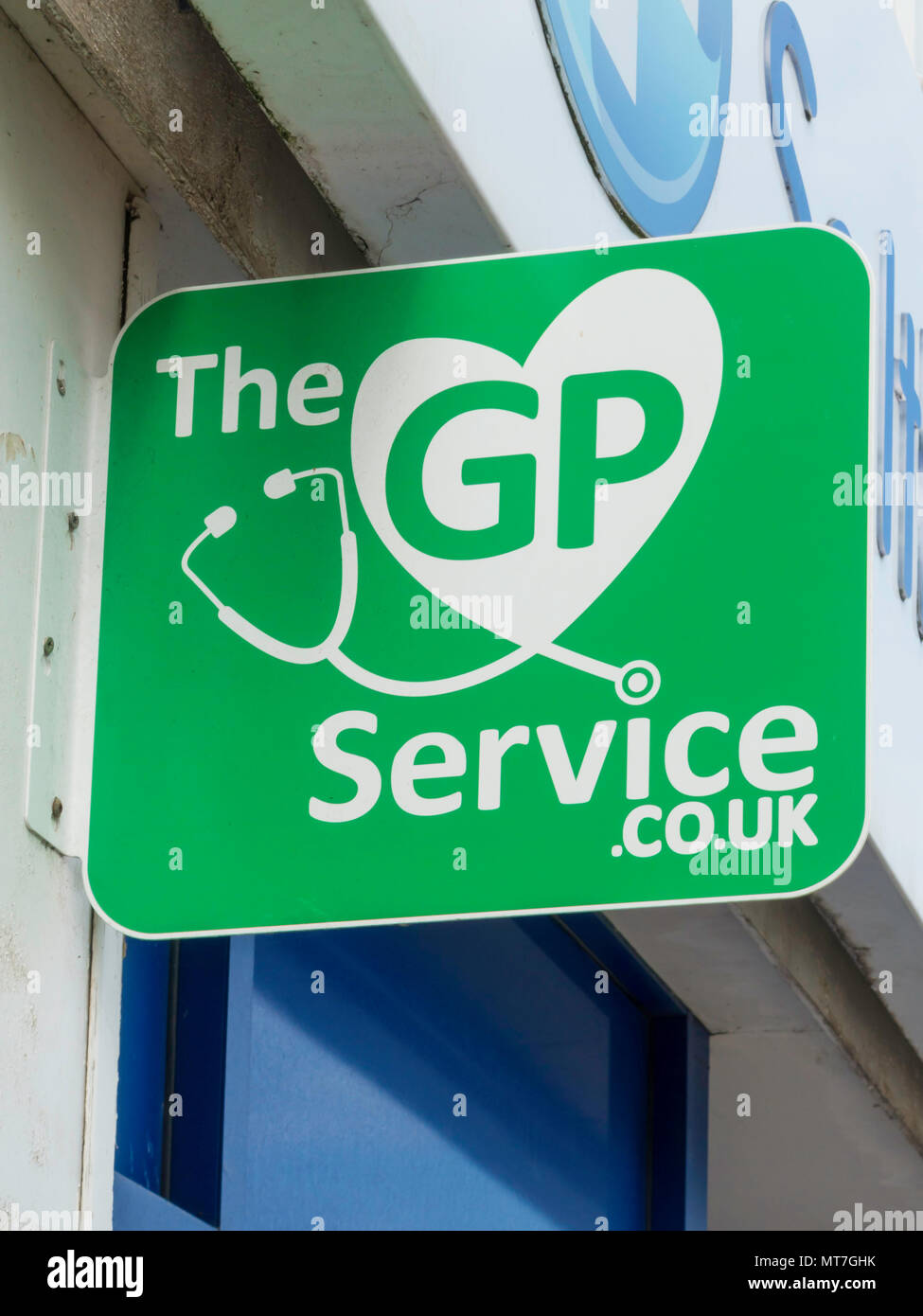 A Green sign on a High Street Pharmacy showing The GP service.co.uk Stock Photo