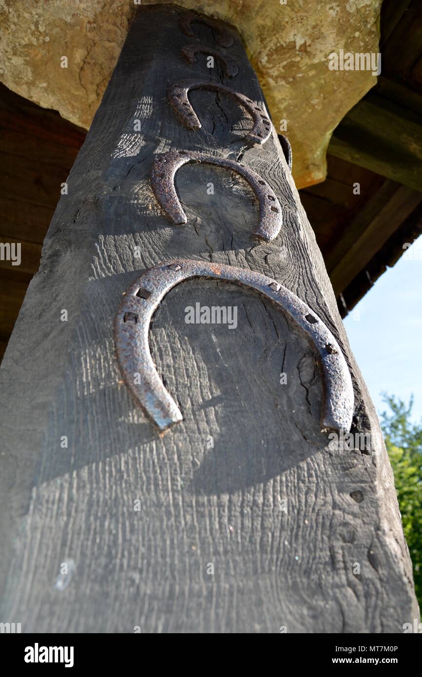 three horseshoes on a wooden column Stock Photo