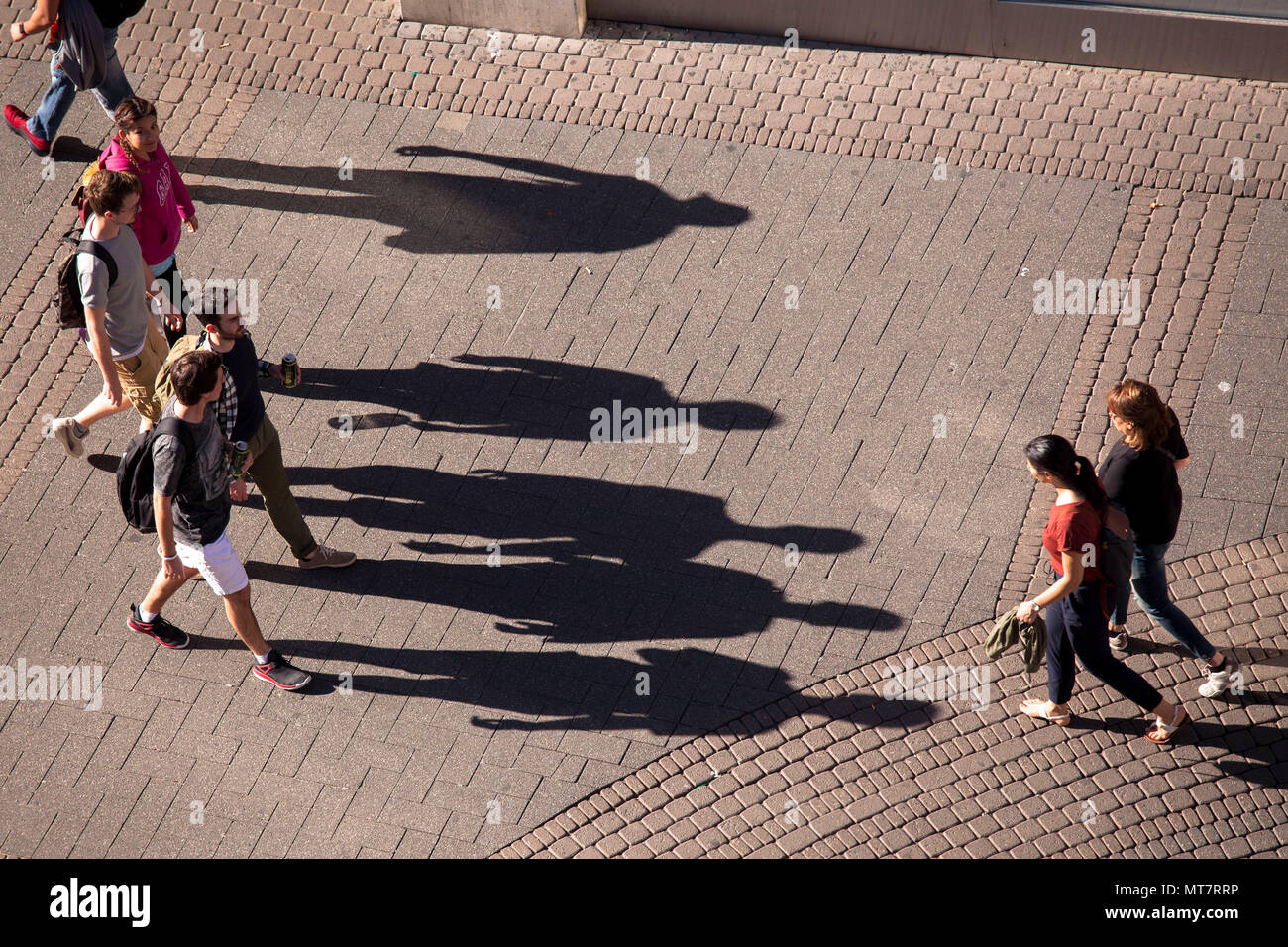 Germany, Cologne, people on the shopping street Schildergasse throw long shadows.  Deutschland, Koeln, Menschen auf der Einkaufsstrasse Schildergasse  Stock Photo
