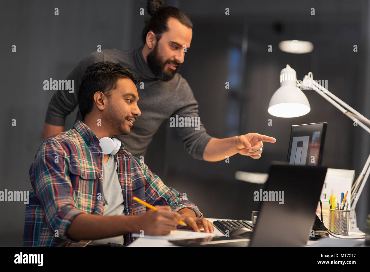 creative team with computer working late at office Stock Photo