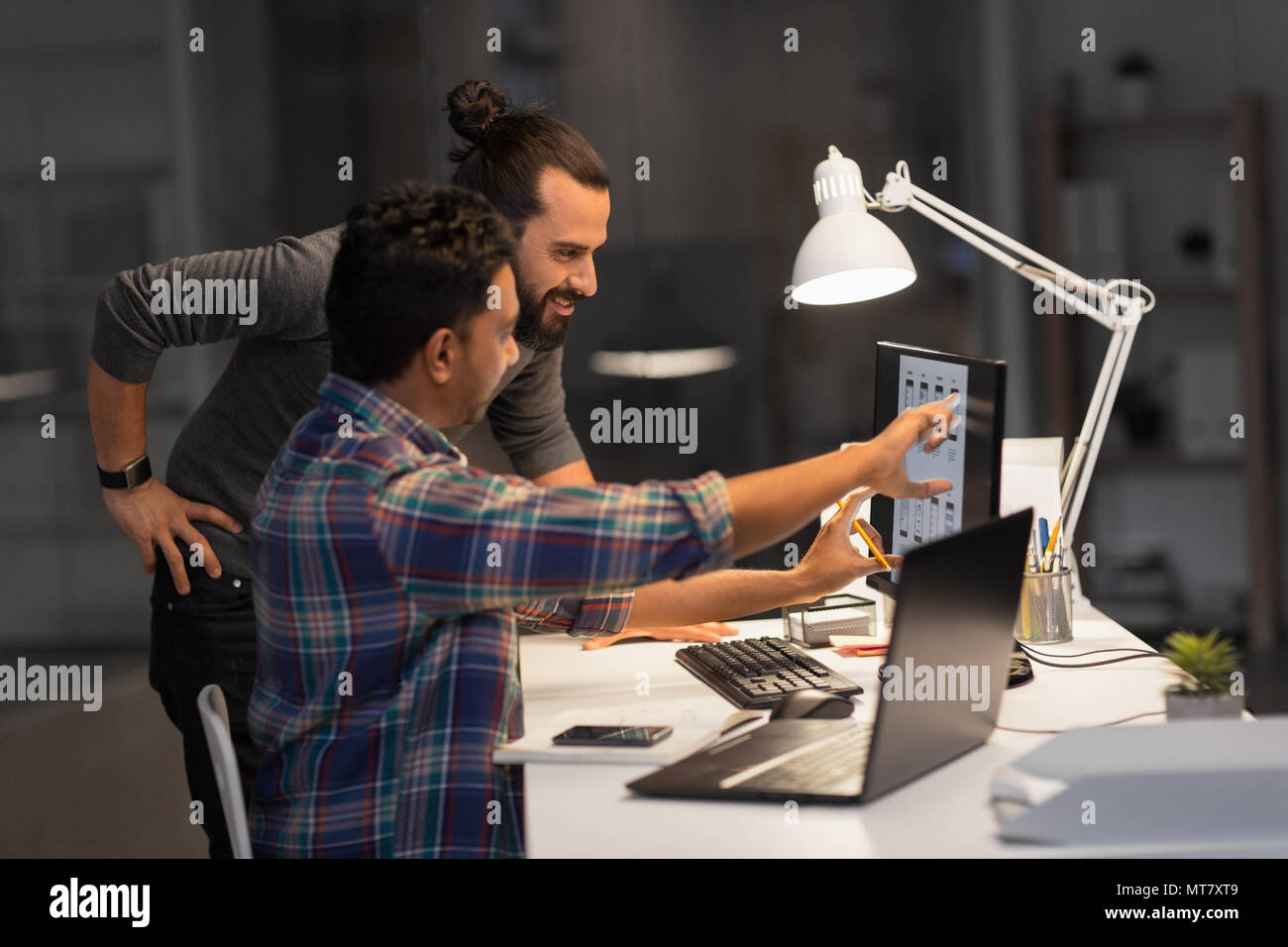 creative team with computer working late at office Stock Photo