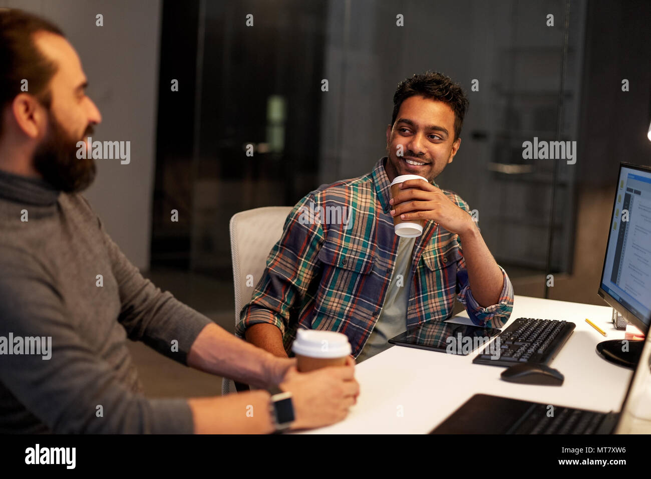 creative team drinking coffee at night office Stock Photo
