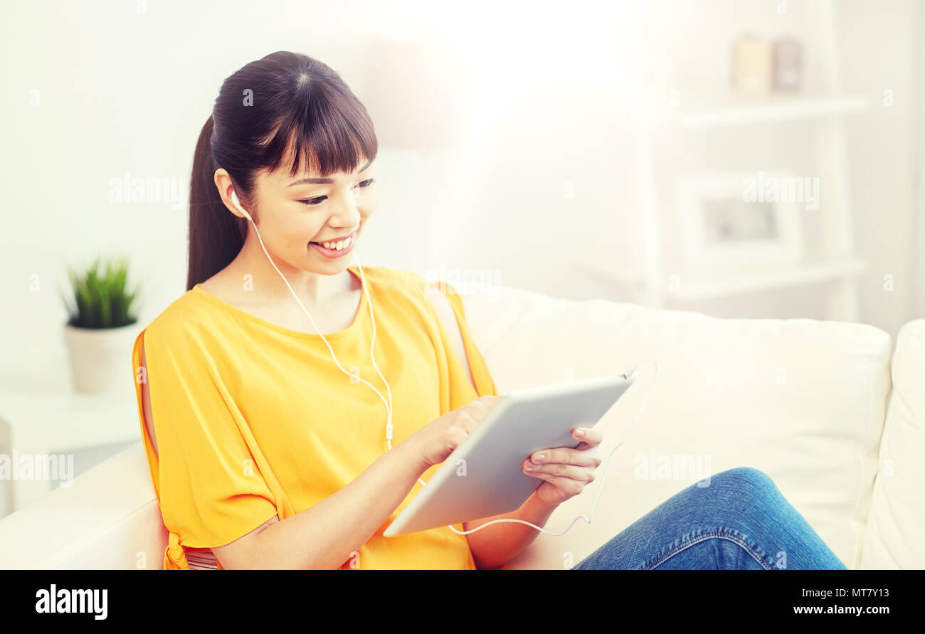 happy asian woman with tablet pc and earphones Stock Photo - Alamy
