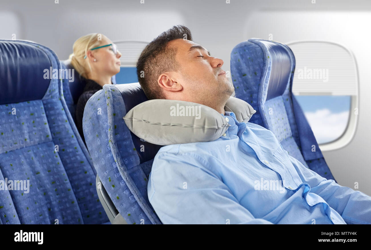 man sleeping in plane with cervical neck pillow Stock Photo Alamy