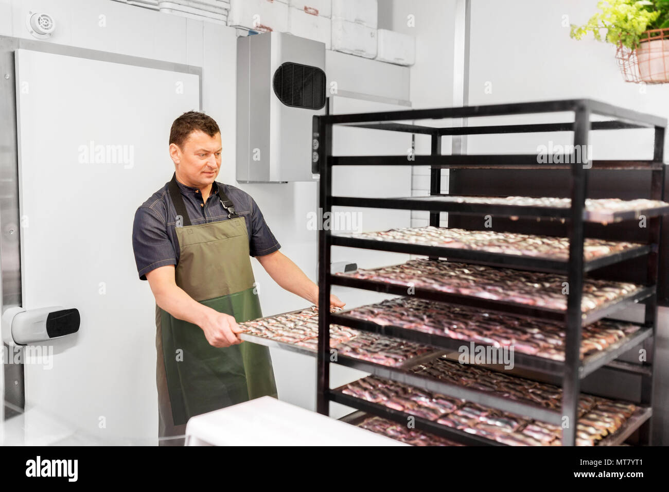 man with smoking tray at fish shop or smokehouse Stock Photo Alamy