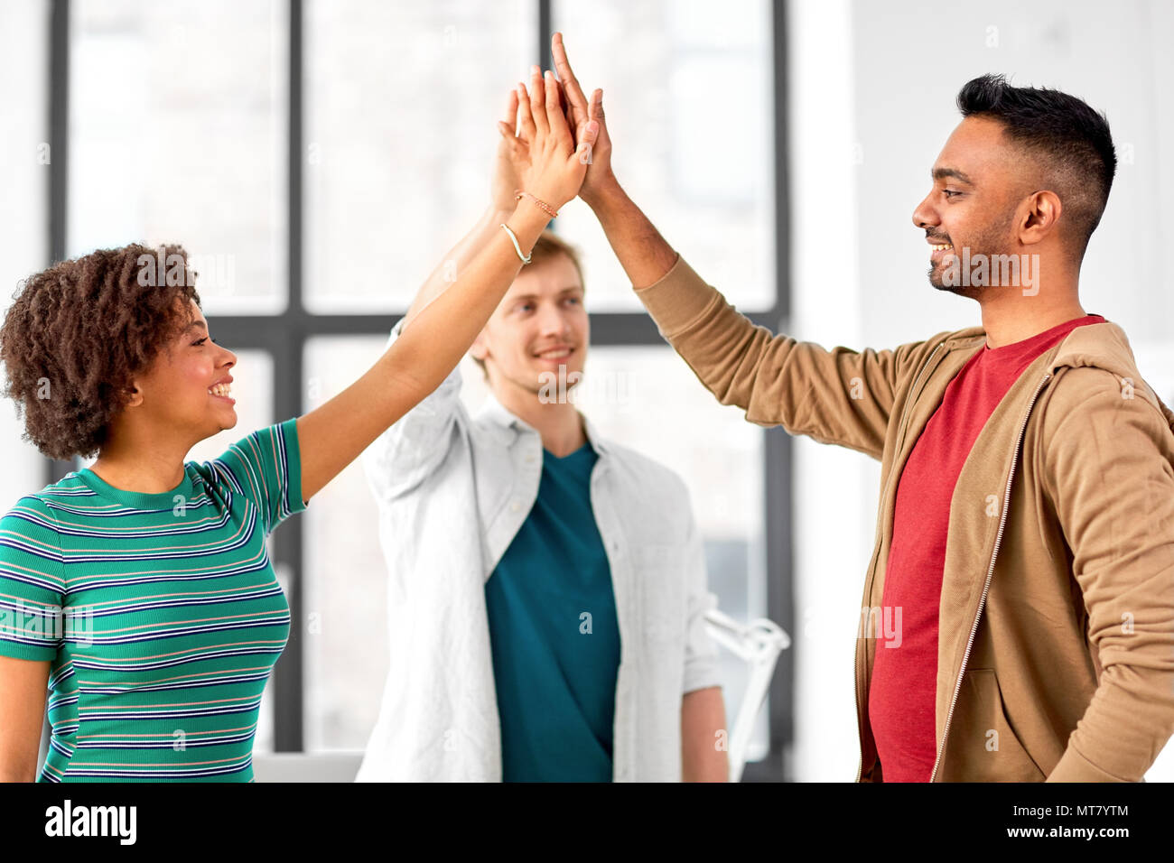 happy creative team making high five at office Stock Photo