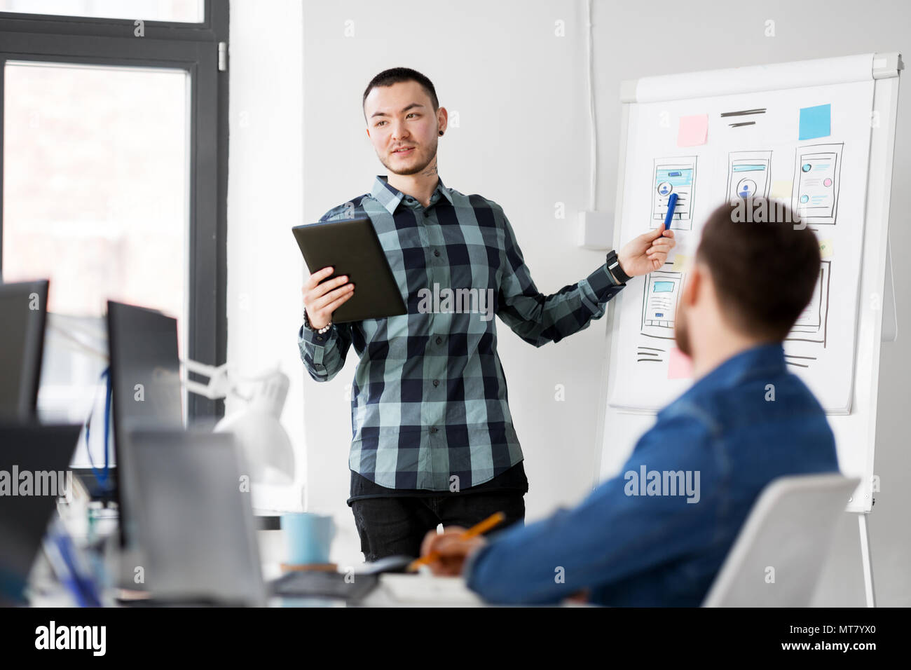 man showing tablet pc to creative team at office Stock Photo