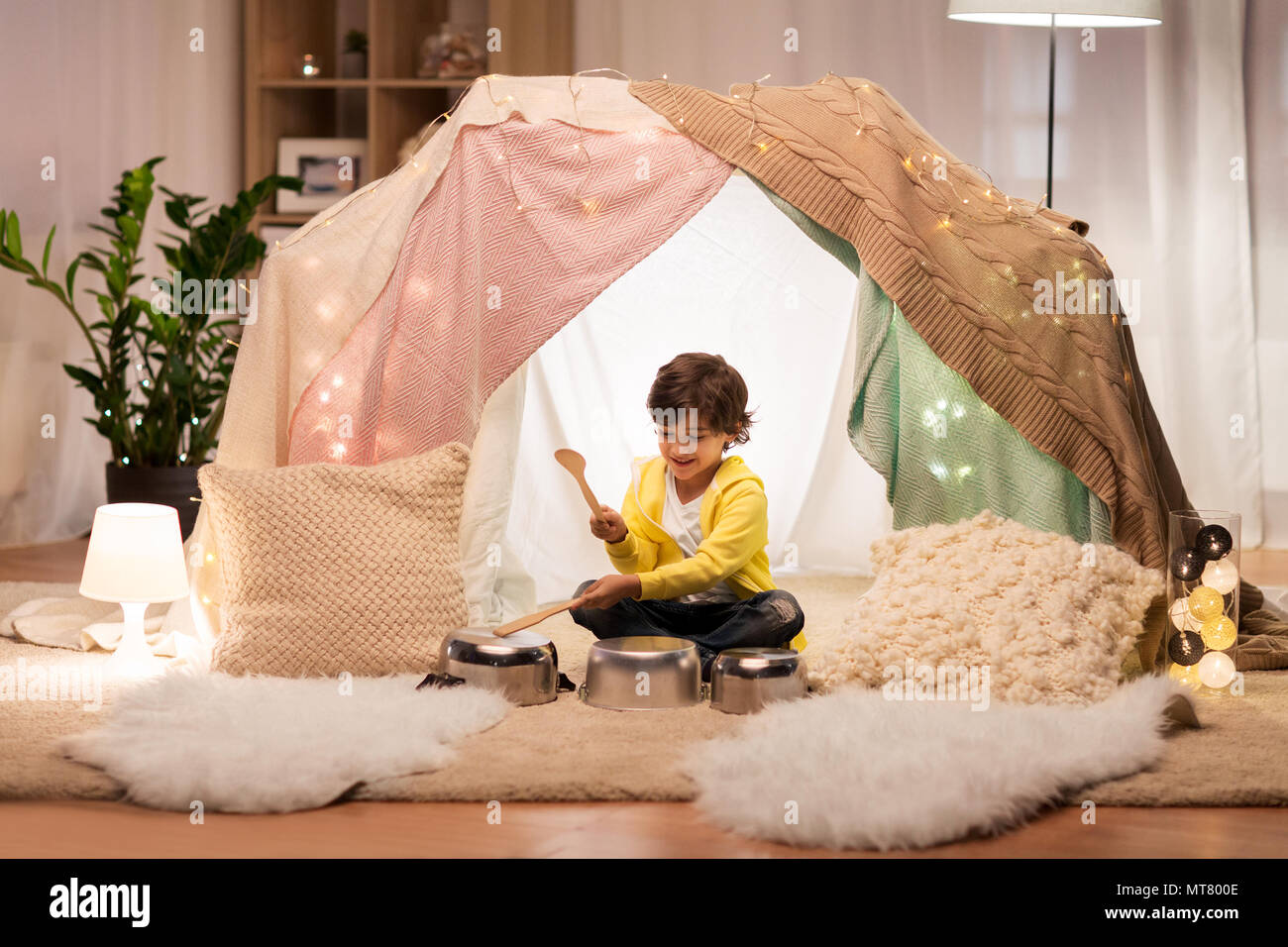 boy with pots playing music in kids tent at home Stock Photo