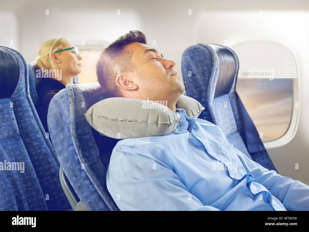 man sleeping in plane with cervical neck pillow Stock Photo Alamy