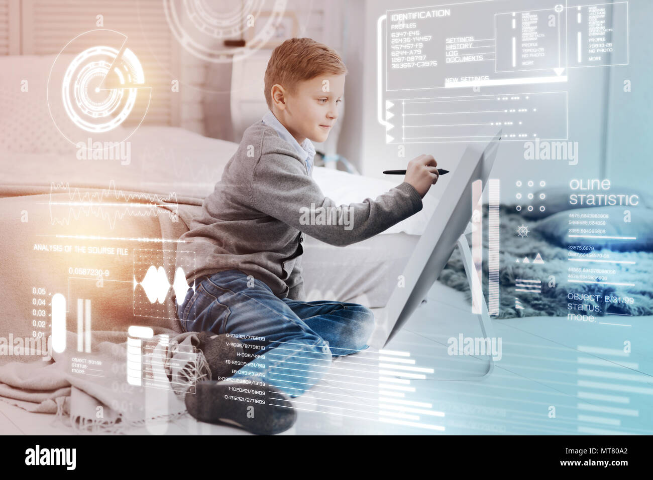 Diligent pupil using modern technologies while doing his homework Stock Photo
