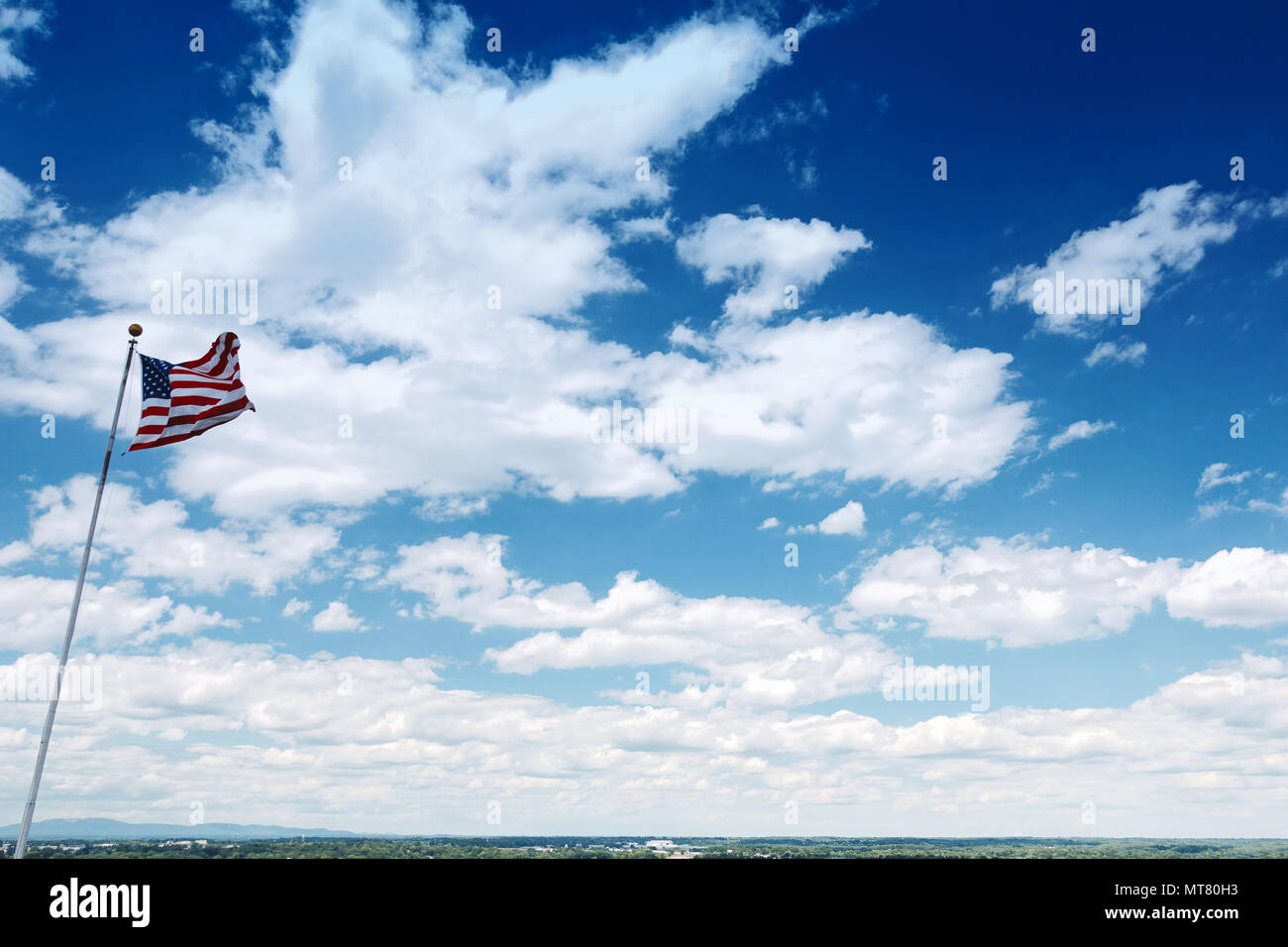 American Flag against Blue Sky and Appalachian Mountains. Stock Photo