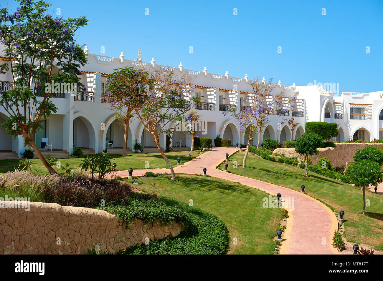 Sharm el-Sheikh, Egypt - April 15, 2018. The courtyards of a magnificent white hotel on a summer day. The concept of tourism, vacations and luxury recreation. Accommodation in Cyrene Grand Hotel Stock Photo