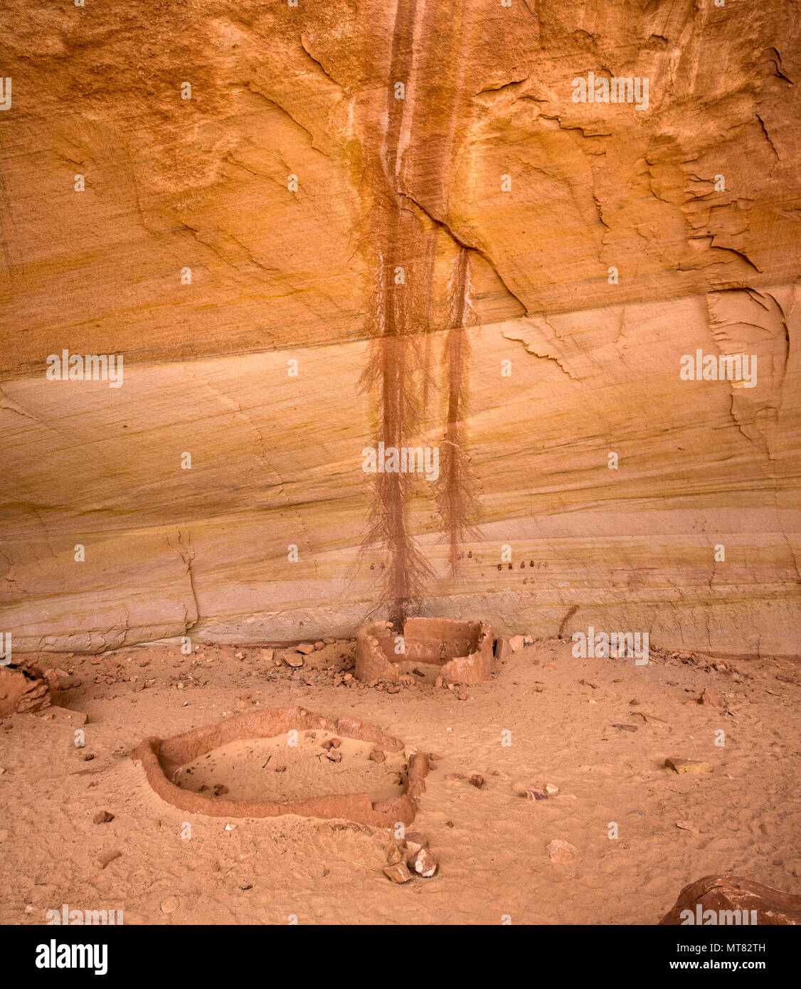 Ancient Ancestral Puebloan historic site structures with handprint pictographs on the back wall of a cliff dwelling in southeastern Utah, United State Stock Photo