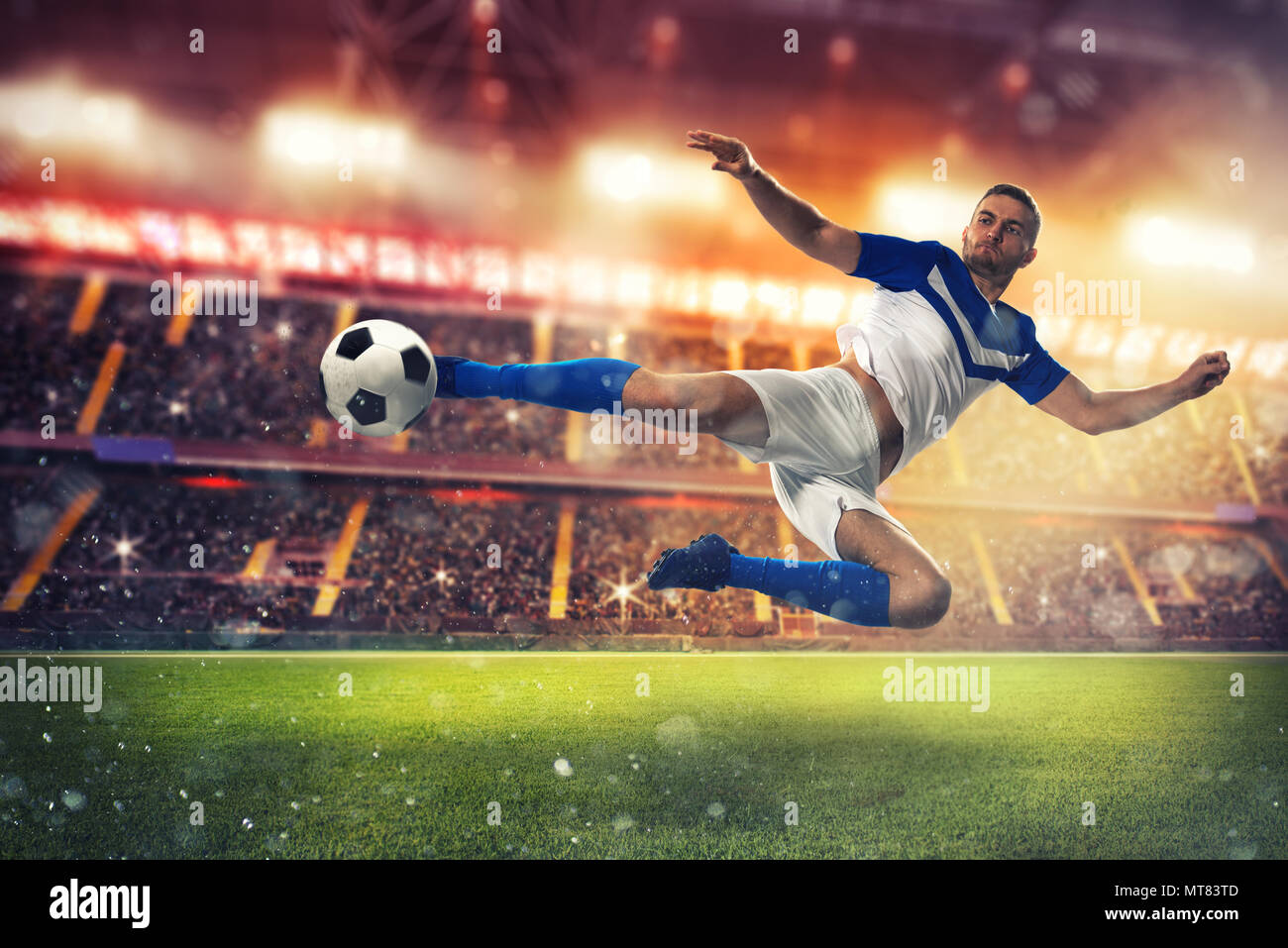 Soccer striker hits the ball with an acrobatic kick Stock Photo