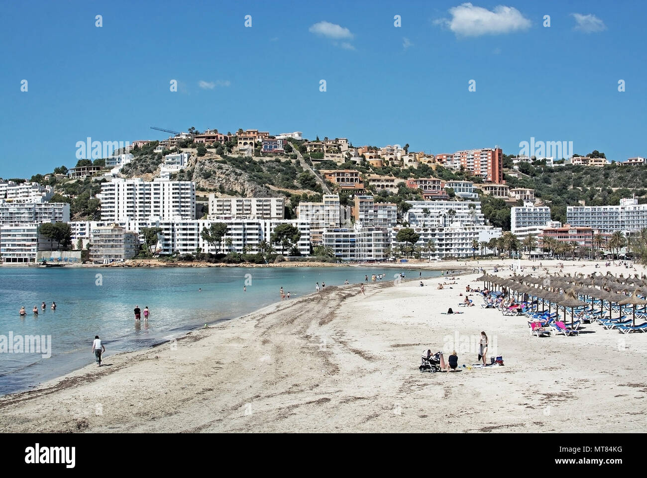 SANTA PONSA, MALLORCA, SPAIN - MAY 10, 2018: Beach resort with tourists and residential homes on the hill above on May 10, 2018 in Santa Ponsa, Mallor Stock Photo