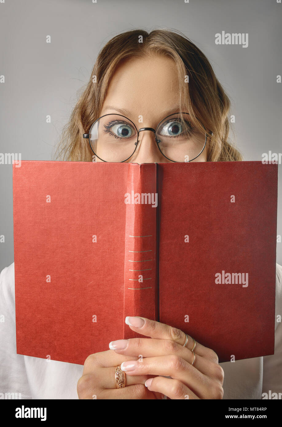 Funny girl with a book in glasses. Stock Photo