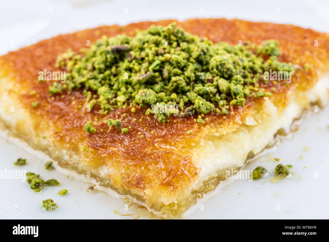 Turkish dessert kunefe, kunafa, kadayif with pistachio powder and