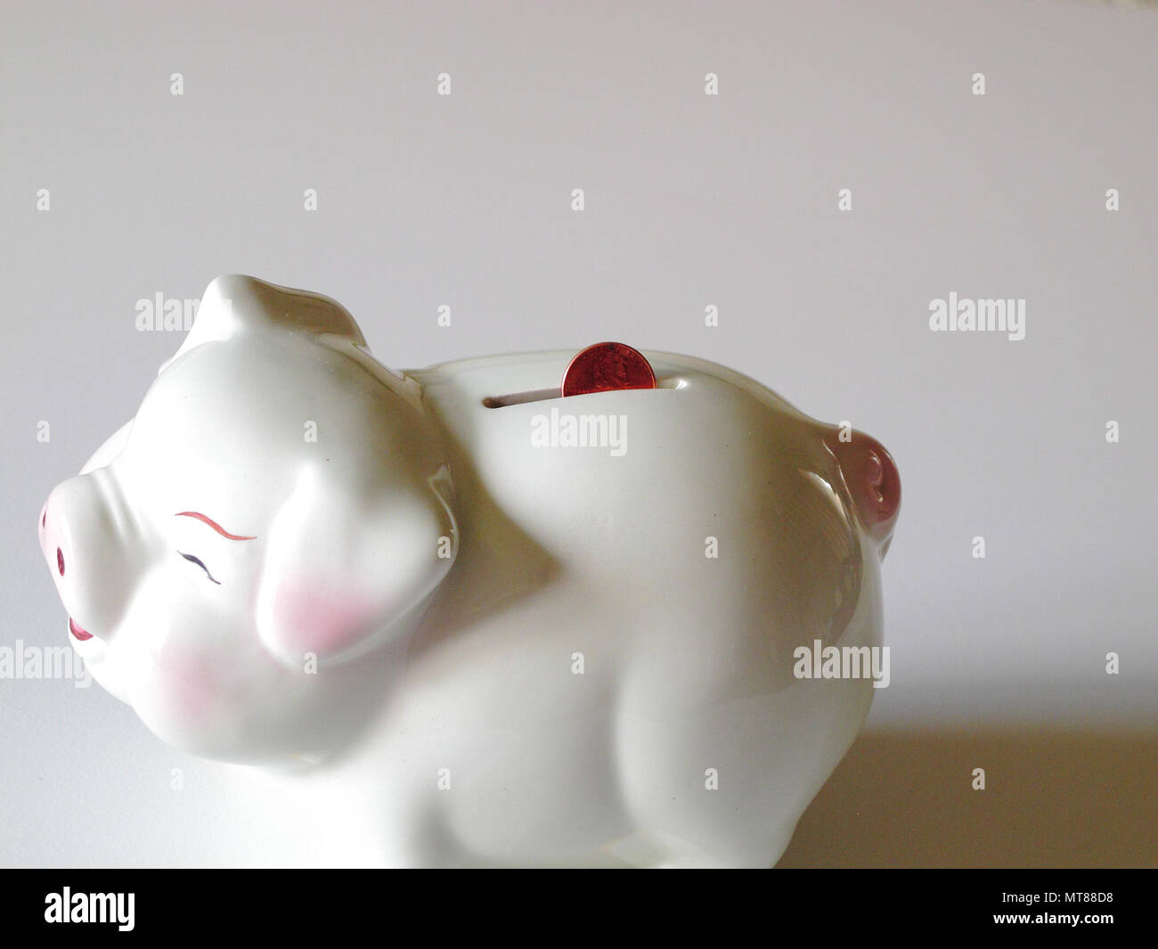 White Ceramic Piggy Bank with Penny in the Slot on White Background ...